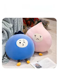 Close-up of cute plush pillows with cartoon faces and legs on a soft knitted blanket