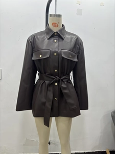 Détail d'une veste longue en similicuir marron foncé avec boutons et ceinture assortie