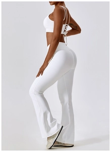 Détail d'un ensemble de yoga blanc avec brassière à dos croisé et pantalon évasé taille haute