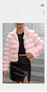 Detail of pink faux fur coat with layered texture on model in outdoor urban street setting