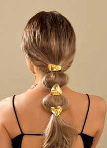 Detail of high-elastic hair tie with metallic gold heart and irregular geometric shapes