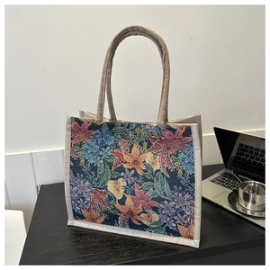 Detailed view of floral jacquard fabric and beige woven handles on the tote bag