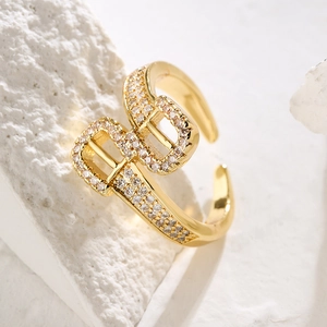 Macro detail of gold-plated adjustable ring featuring pavé zircon interlocking B design