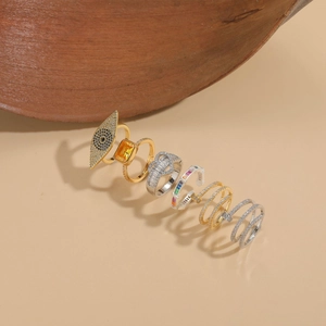 Detailed arrangement of gold and silver zircon rings featuring eye and geometric designs