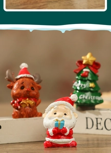 Close-up of resin Christmas miniatures with Santa and reindeer on white book props