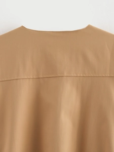 Detail view of khaki bomber jacket neckline showing stitching and fabric texture