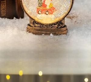 Detail of Christmas lantern snow globe with Santa Claus scene and bronze deer base