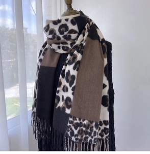 Detail of leopard print cashmere scarf with tassel hem and neutral color blocking