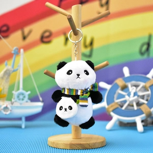 Detailed view of a plush panda keychain featuring a striped scarf and mini panda backpack.