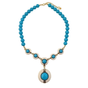 Vintage gold necklace with turquoise resin beads and circular pendant on a white background