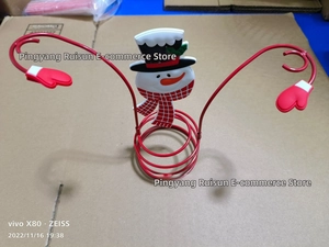 Detailed view of snowman holiday wine holder with red spiral metal base and hand hooks