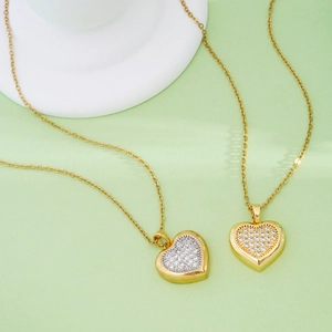 Gold and silver heart pendant necklaces with white zircon pavé on a stone pedestal