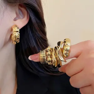 French vintage gold earrings and ring set with textured liquid metal design on model