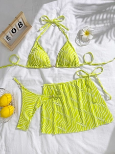Three-piece neon green bikini set with halter top and skirt on white background