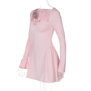 Détail d'une robe rose à manches longues montrant l'ourlet froncé et le col carré sur mannequin