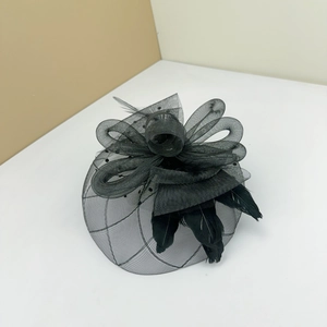 Detail of elegant black fascinator with mesh bow and feathers for vintage parties