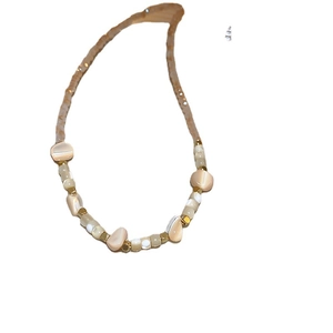 Irregular shell beaded necklace with artificial crystals and gold hardware on white background