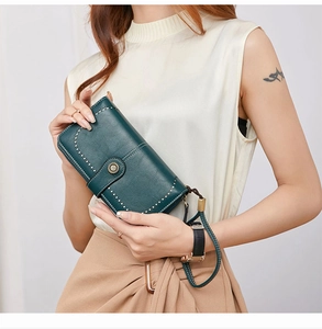 Detail of dark green RFID leather wallet with contrast stitching and wrist strap