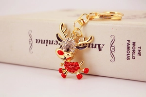 Close-up of golden reindeer keychain pendant with sparkling clear and red crystals