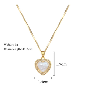 Detail of gold heart pendant with white shell inlay, cubic zirconia, and dimensions