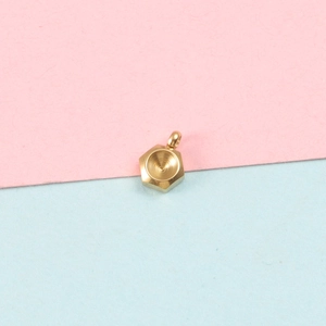 Detail of a golden hexagonal pendant with round stone tray on a soft pastel background
