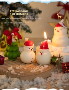 Christmas tree and snowman scented candle set on wooden tray with festive snow decor