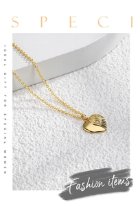 Detailed macro view of golden heart-shaped wing pendant on a delicate chain necklace