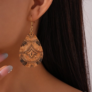 Detail of drop-shaped cork earring with black mandala pattern on ethnic jewelry