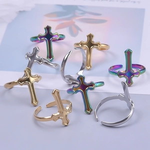 Detailed view of adjustable cross rings in gold, silver, and rainbow plated finishes