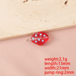 Vista macro di ciondolo a conchiglia in vetro rosso con punti blu per gioielli fai-da-te