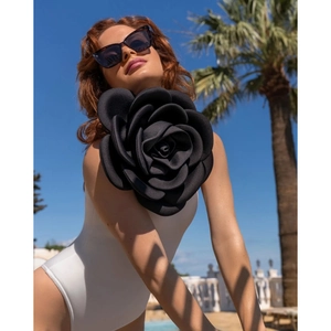 Detailansicht einer großen schwarzen 3D-Rose auf einem weißen Badeanzug für den Urlaub