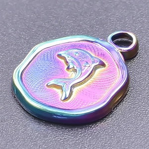 Macro view of a rainbow gradient dolphin relief pendant in luxury stainless steel