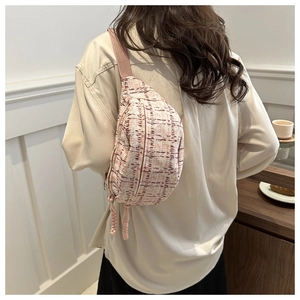 Detail of pink tweed checkered waist bag featuring fringe zipper on female model