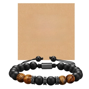 Macro detail of tiger eye beads and matte onyx bracelet with inspirational gift card