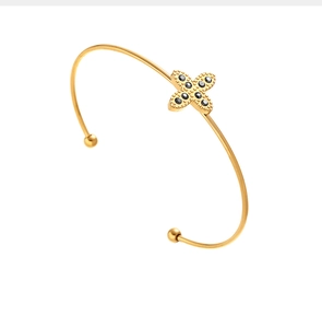 Détail d'un bracelet jonc doré orné d'un motif de croix et cristaux noirs