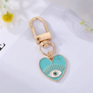 Golden heart keychain with light blue enamel finish and evil eye pattern charm