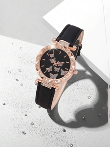 Detail of rose gold watch with butterfly dial and black leather strap among water drops