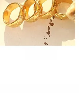 Detail of 18K gold-plated rings with quilted texture and polished metal finish
