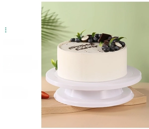 Close-up of a white food-grade PP cake rotating turntable with a decorated cake