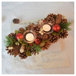 Close-up of vintage Christmas candle holder with pine cones and red berries on snow