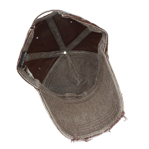 Detail of vintage washed cotton baseball cap showing frayed brim and metal buckle strap