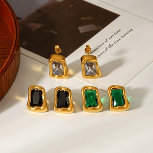 Détail de boucles d'oreilles irrégulières en or et zircon blanc, noir et vert émeraude