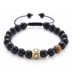 Detail of tiger eye and black agate beads with a gold square letter Q zircon charm