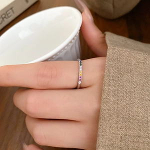 Detail of s925 silver ring with rainbow colorful zircons on a model's finger