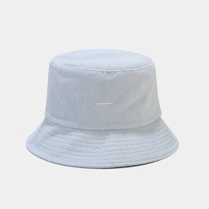 Detailed view of light blue towel fabric bucket hat with white embroidery and soft texture