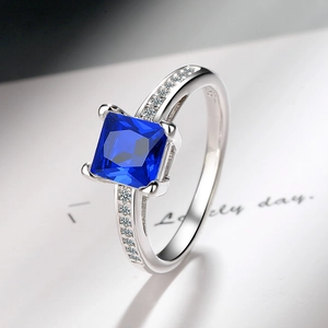 Macro shot of S925 silver ring featuring square blue zircon and detailed side stones