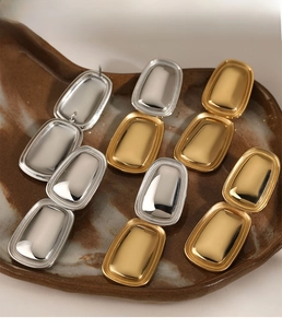 Detail view of rectangular geometric drop earrings in gold and silver matte finishes