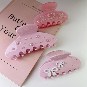 Three-piece set of pink claw clips with rhinestone bows, pearls, and gradient floral patterns