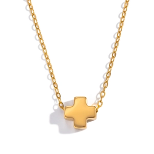 Macro view of gold stainless steel cross pendant necklace with polished mirror finish