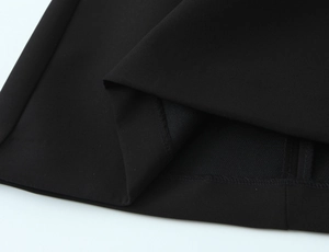Detailed close-up of double-stitched black polka dot fabric with high-quality texture